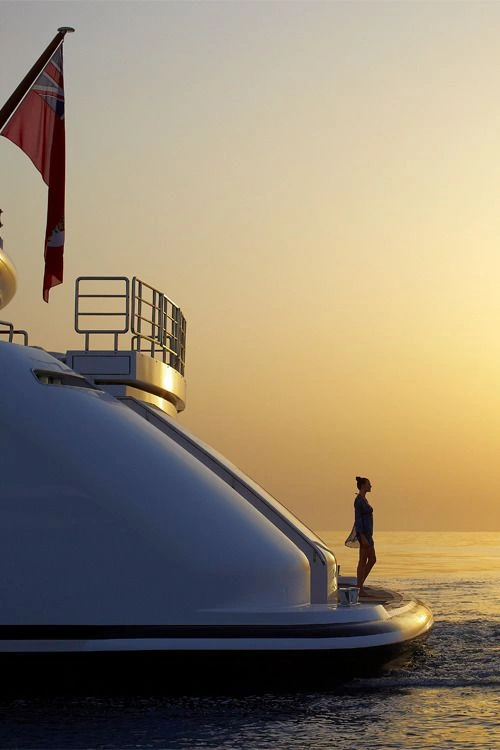 Guest on a superyacht swim platform at golden hour